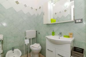 a bathroom with a toilet and a sink and a mirror at San Teodoro Monti22 vicino spiaggia in San Teodoro