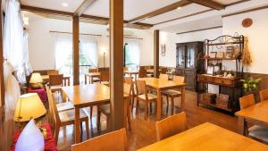a dining room with wooden tables and chairs at Anise Garden Lodge in Hakuba