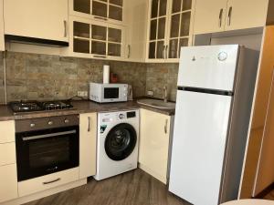 a kitchen with a white refrigerator and a washing machine at Cozy corner Komitas in Yerevan