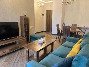 a living room with a blue couch and a television at Cozy corner Komitas in Yerevan