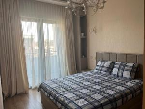 a bedroom with a bed and a large window at Cozy corner Komitas in Yerevan