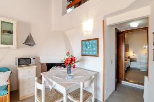 a dining room with a white table with flowers on it at Trilocale Taverna 80 mt spiaggia in Porto Taverna