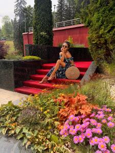 a woman sitting on the stairs talking on a cell phone at Hotel Piatra Mare in Poiana Brasov
