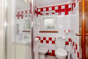 a red and white bathroom with a toilet and a sink at Trilocale Taverna 80 mt spiaggia in Porto Taverna +15 photos