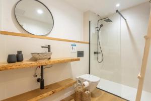a bathroom with a shower and a toilet and a mirror at MAAR Suites Cotillo in El Cotillo +38 photos