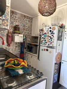 a kitchen with a refrigerator with a bowl of fruit on the counter at Apartamento Praia da Costa in Vila Velha +120 photos