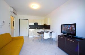 a living room with a couch and a table with a television at Villaggio Sant'Andrea in Caorle