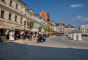 a person riding a motorcycle down a street with buildings at Cieszyński by Imperis Hotels in Cieszyn