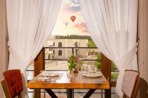 a table with a view of hot air balloons at Cappadocia Golden Elite in Uçhisar