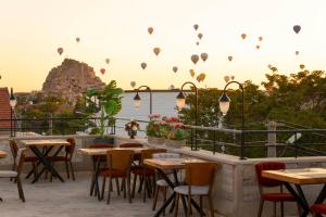 a restaurant with tables and chairs on a patio at Cappadocia Golden Elite in Uçhisar