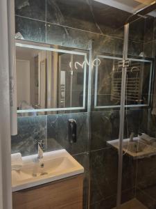 a bathroom with a sink and a mirror at Kergoat in Carhaix-Plouguer