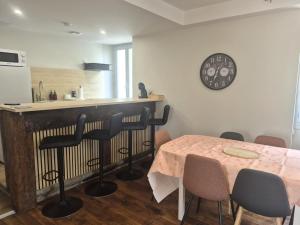 a kitchen with a table and a clock on the wall at Kergoat in Carhaix-Plouguer