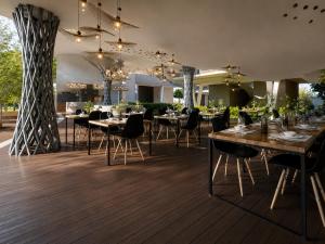 a restaurant with wooden floors and tables and chairs at Rekawa Reach Tangalle in Tangalle