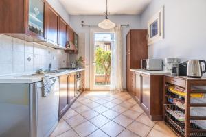 a kitchen with wooden cabinets and a tile floor at Alloggio Poseidone in Villasimius