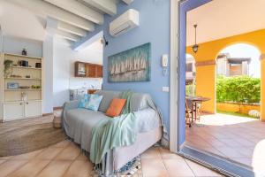 a living room with a bed and a mirror at Alloggio Poseidone in Villasimius