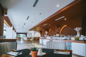 a restaurant with tables and chairs and a bar at Omar Hotel in Tangerang +37 photos