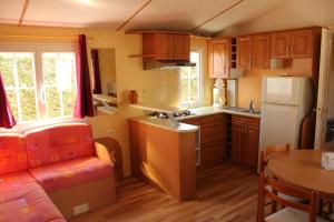 a small kitchen with a sink and a refrigerator at Camping de la Rive in Notre-Dame-de-Monts +14 photos