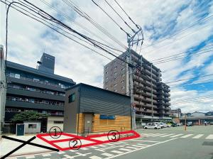 a street with a building and a crosswalk at みんなの宿Kumamoto in Kumamoto