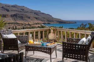 a patio with chairs and a table with food on it at Terra Minoika Boutique Resort in Kato Zakros
