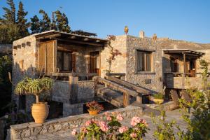 an old house with flowers in front of it at Terra Minoika Boutique Resort in Kato Zakros
