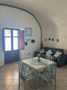 a table and chairs in a living room with a couch at Melania Home II in Filicudi