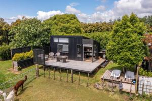 a small black tiny house with a deck at Fig Cottage in New Plymouth +33 photos