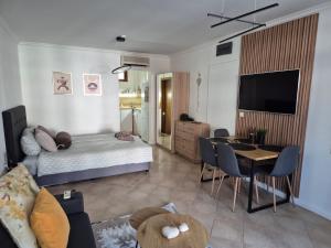 a living room with a bed and a dining room at Eve Santa Marina Studios - sea, pools, relax in Sozopol
