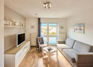 a living room with a couch and a tv at Elbe I, Ferienwohnung 29 in Cuxhaven