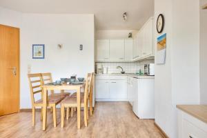 a kitchen and dining room with a table and chairs at Elbe I, Ferienwohnung 29 in Cuxhaven +3 photos