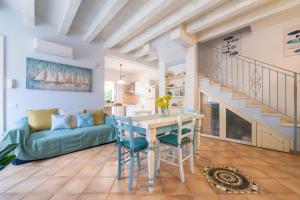 a living room with a table and chairs and a staircase at Alloggio Nettuno in Villasimius