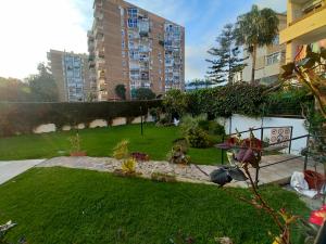 a backyard with a grassy yard with buildings at Iris Summer Beach in Benalmádena