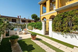 a garden with potted plants in front of a house at Alloggio Nettuno in Villasimius