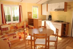 a kitchen and dining room with a table and chairs at Camping de la Rive in Notre-Dame-de-Monts