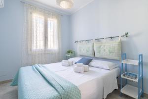 a blue bedroom with a white bed with towels on it at Alloggio Nettuno in Villasimius