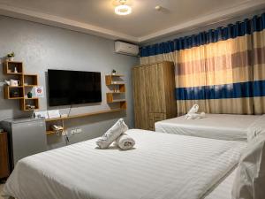 a hotel room with two beds and a flat screen tv at Valentine Hotel Angeles City managed by Cocotel in Angeles +14 photos