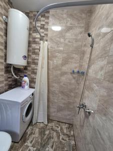 a bathroom with a shower and a washing machine at Къща за гости Бавария in Ravda