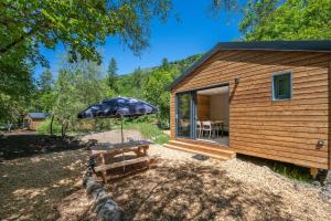 a small cabin with an umbrella and a picnic table at Hôtel et Camping O2 Orcières Outdoor Area in Orcières