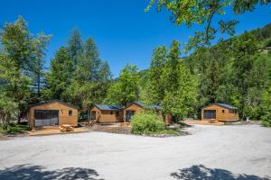 a group of cabins in the woods with a parking lot at Hôtel et Camping O2 Orcières Outdoor Area in Orcières