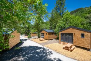 a group of wooden cabins in a park at Hôtel et Camping O2 Orcières Outdoor Area in Orcières