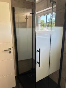 a bathroom with a glass door with a cross on it at Haus Bernd Joachimsthal am Grimnitzsee in Joachimsthal +13 photos