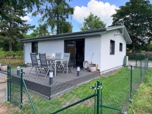 a small white house with a table and chairs at Haus Bernd Joachimsthal am Grimnitzsee in Joachimsthal