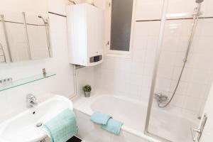 維也納的住宿－Apartment Dieselgasse，白色的浴室设有水槽和淋浴。