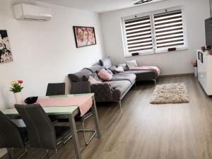 a living room with a couch and a table at Móra Apartman in Pécs