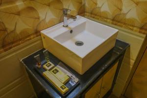 a white sink on a black counter in a bathroom at Mohar Residency - VIP Road in kolkata +16 photos