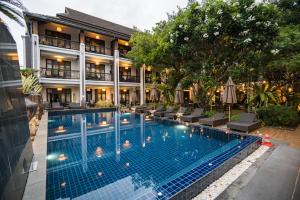 a swimming pool in front of a hotel at De Lanna Hotel in Chiang Mai