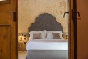 a bedroom with a large bed with a large headboard at Palazzo Venneri Lloyd - Historic Heritage Palazzo in Gallipoli