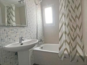 a white bathroom with a sink and a bath tub at Apartamentos Las Arenas 3000 in Alcossebre +29 photos