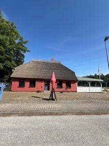 a red building with a black roof at Ferienwohnung Sternenhimmel in Dranske