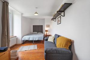 a living room with a couch and a bed at La Bourgerie in Saint-Aubin-des-Bois