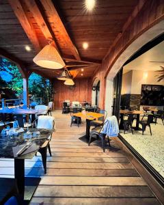 a restaurant with wooden floors and tables and chairs at Hôtel du Golfe Pinarello in Pinarellu